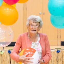 resident with beach ball at friary care summer ball