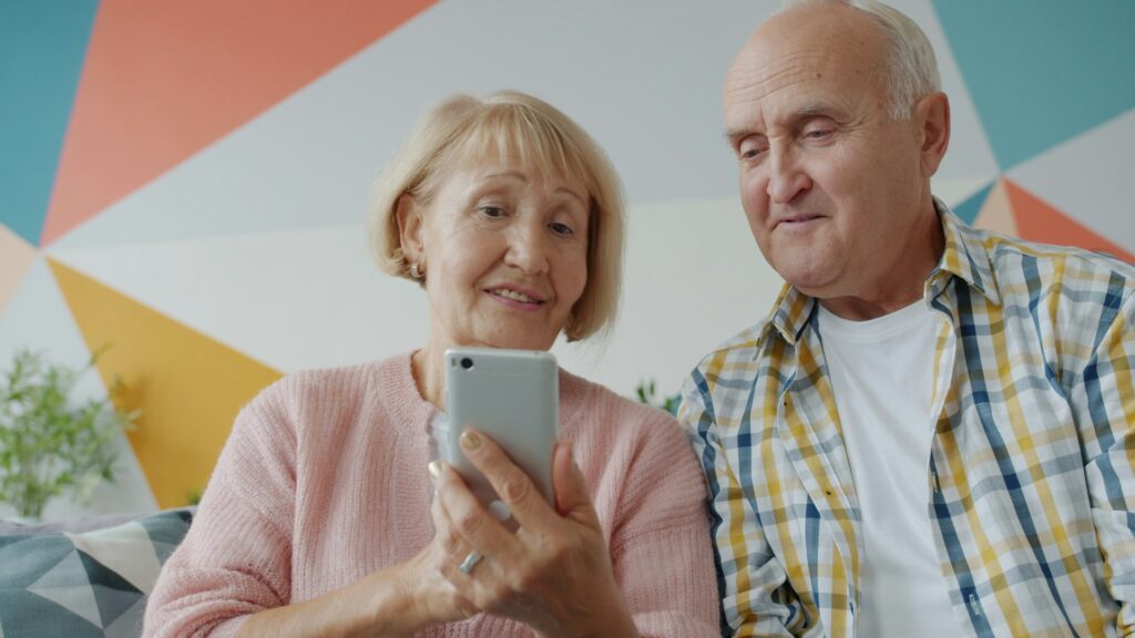 elderly couple playing game on mobile phone