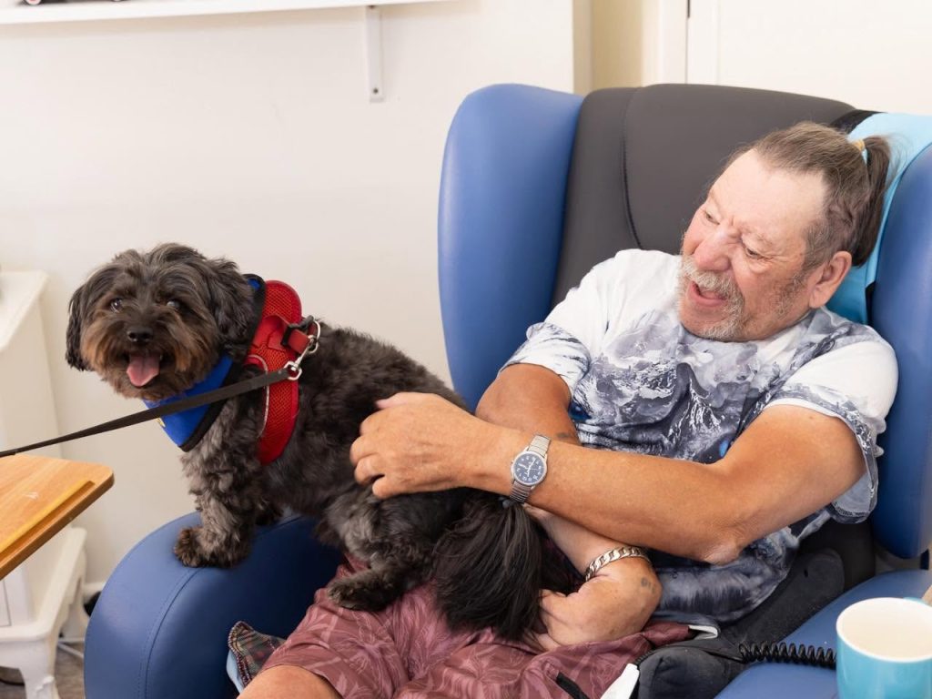 happy resident with friary care therapy dog